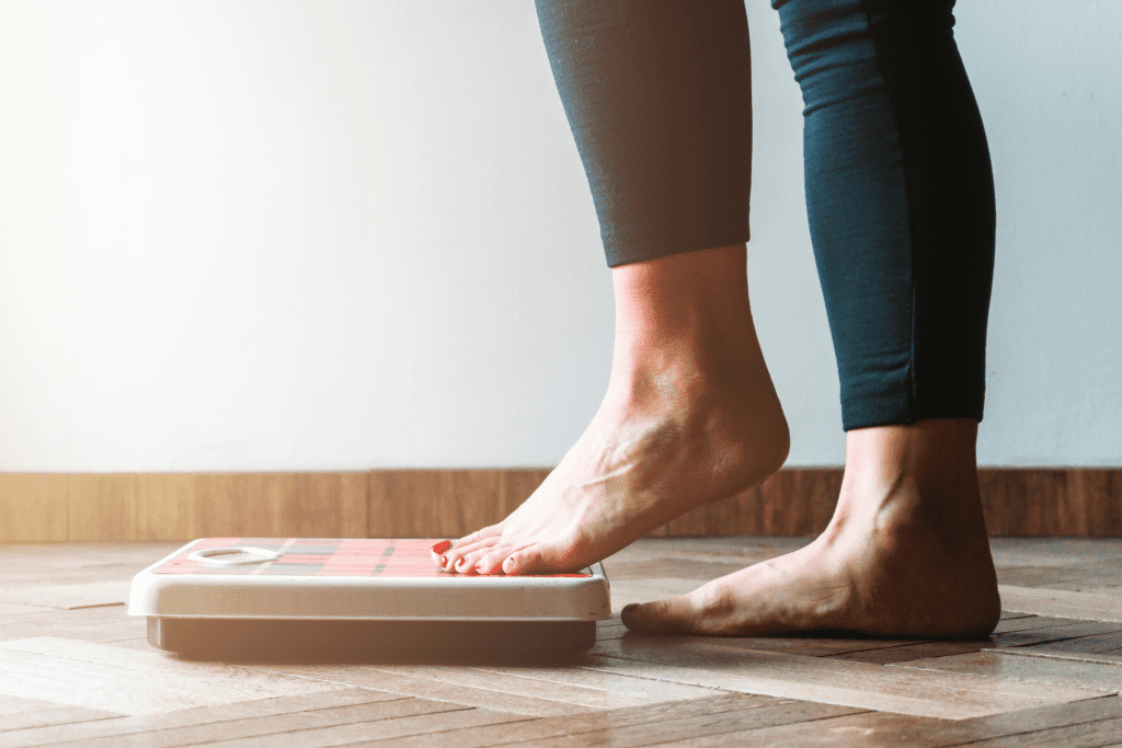 How often should you weigh yourself? - Woman stepping onto the scale